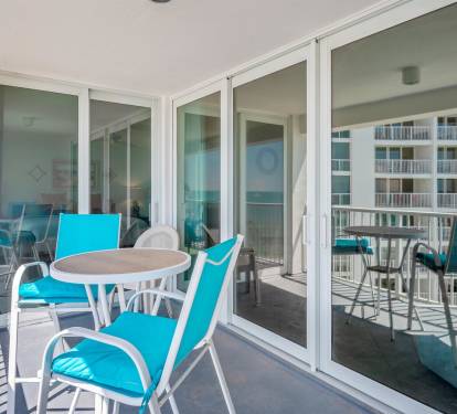 Step onto your private balcony with turquoise seating and enjoy morning coffee while taking in views of neighboring buildings.