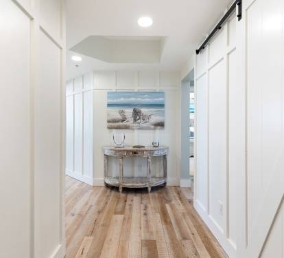 Step into your welcoming foyer where coastal art and warm wood floors create an instant sense of home and relaxation.