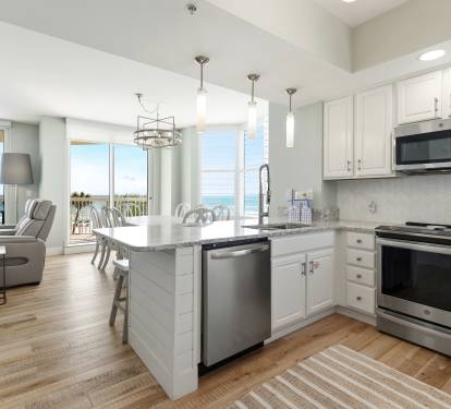 Your stunning oceanfront kitchen features premium appliances and granite counters, while floor-to-ceiling windows frame breathtaking sea views for memorable coastal cooking.