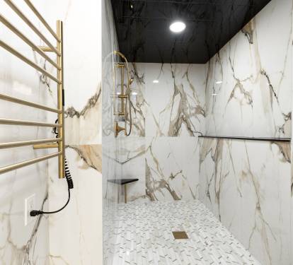 Luxurious marble shower with gold fixtures and heated towel rails creates your personal spa sanctuary.