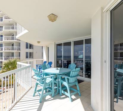 Your private balcony features turquoise dining chairs and table where you can enjoy meals with ocean breezes and coastal views.