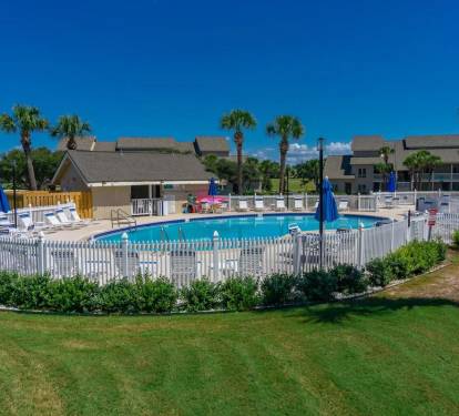 Take a refreshing dip in the sparkling community pool, surrounded by palm trees and relaxing coastal vibes just moments from your vacation retreat.