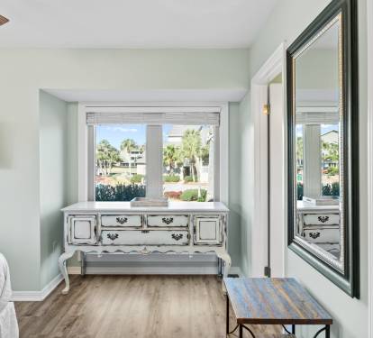 Relax in the inviting primary bedroom featuring coastal-inspired décor, comfortable furnishings, and a peaceful atmosphere perfect for unwinding after a day at the beach.