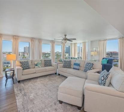 Unwind in your spacious living room with panoramic city views through floor-to-ceiling windows and comfortable seating for the whole group.