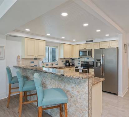 Your fully equipped kitchen awaits with granite counters, stainless appliances, and breakfast bar seating for casual coastal dining.