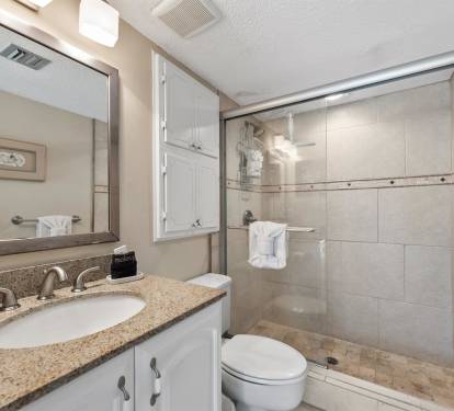 Relax in your private bathroom featuring granite counters, spacious shower, and crisp white towels waiting for you.