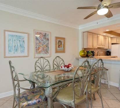 Your elegant dining space features a glass table perfect for family meals, complemented by an open kitchen design.