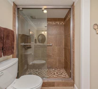 Step into your spa-like bathroom where warm earth tones and elegant tile work create a peaceful retreat for refreshing after beach days.