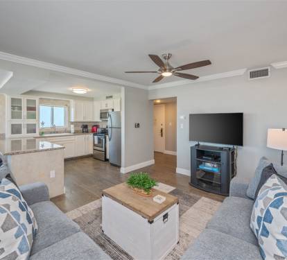 Relax in your open-concept living space with plush seating, modern kitchen, and entertainment center - your coastal getaway awaits.