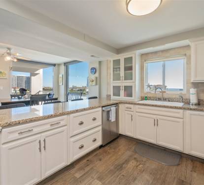 Your fully equipped kitchen opens to stunning ocean views, perfect for cooking while enjoying the coastal scenery through panoramic windows.