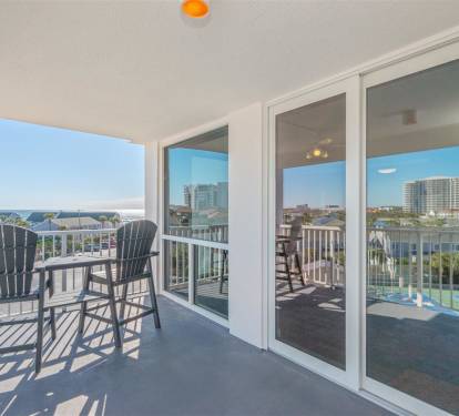 Step onto your private balcony where two chairs await for morning coffee or evening relaxation, surrounded by coastal views and city skyline.