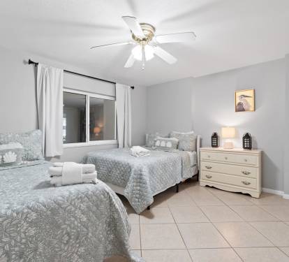Your peaceful twin bedroom features comfortable beds with soft linens, gentle ceiling fan, and warm lighting for restful nights.