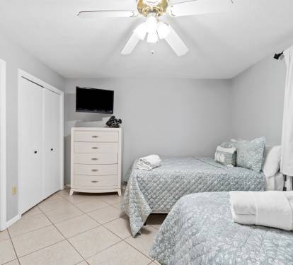 Your peaceful bedroom features twin beds with soft linens, wall-mounted TV for relaxation, and ample wardrobe storage for your belongings.