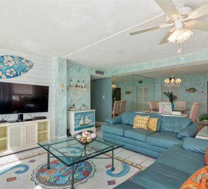 Relax in your tropical-themed living room with ocean blues, cozy seating, and beachy decor creating the perfect coastal retreat ambiance.