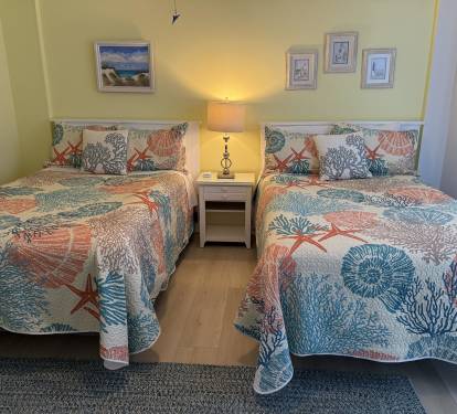 Drift off in comfort with twin beds dressed in coastal-themed linens featuring coral and starfish patterns that'll transport you to the seaside.