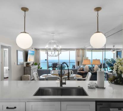 Prepare your favorite meals in a sleek, modern kitchen while enjoying stunning gulf views through floor-to-ceiling windows. The open layout flows into a welcoming living space, perfect for your getaway.