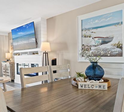 Gather around your spacious dining table where ocean views and coastal artwork create the perfect backdrop for memorable meals together.