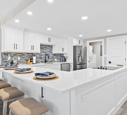 Your modern kitchen features pristine white cabinetry, gleaming quartz countertops, and premium stainless steel appliances for effortless meal preparation.