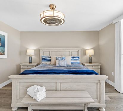 Drift off in your coastal-themed bedroom with ocean artwork and soft blue linens, while natural light fills the space.