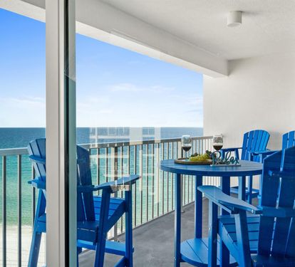 Step onto your private balcony where vibrant blue furniture awaits for oceanfront dining with endless sea views.