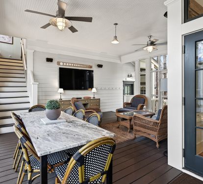 Your elegant screened porch offers the perfect blend of comfort and coastal charm with ceiling fans, dining space, and cozy seating.