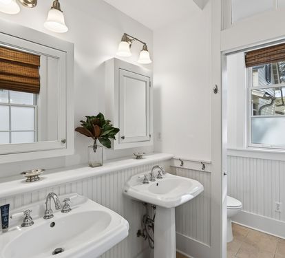 Step into your beautifully appointed bathroom with dual pedestal sinks, perfect for your morning routine together.