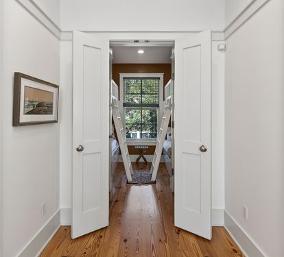 Step through these elegant double doors into your beautifully appointed space, where warm hardwood floors and tasteful decor create a welcoming atmosphere.
