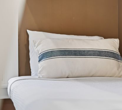 Sink into crisp white linens and soft pillows for a peaceful night's rest in your cozy bedroom retreat.