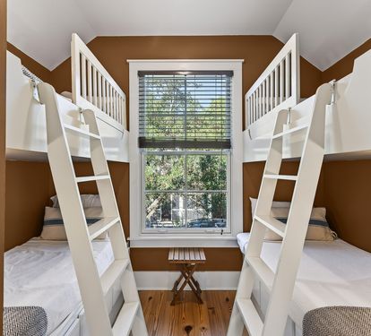 Rest in your cozy bunk room where modern comfort meets playful design, complete with crisp linens and peaceful garden views.