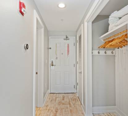 Welcoming entryway with coastal tones, wood-style floors, and a convenient open closet—setting the stage for your relaxing 30A beach stay.