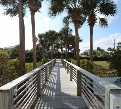 Wooden walkway leading to a pond.