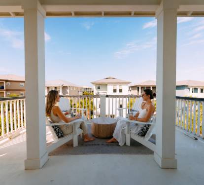 Enjoy morning coffee or sunset drinks on your private balcony with peaceful views of the charming beachside neighborhood. 