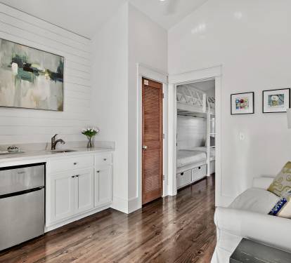 3rd floor sitting area features a wet bar with sink and mini fridge and opens to the large 3rd floor porch that overlooks the neighborhood