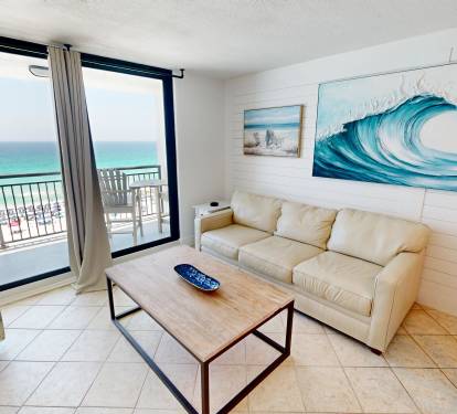 Unwind in your bright, beachy living room where ocean waves inspire the art and your private balcony opens to stunning sea views—perfect for morning coffee or sunset drinks.