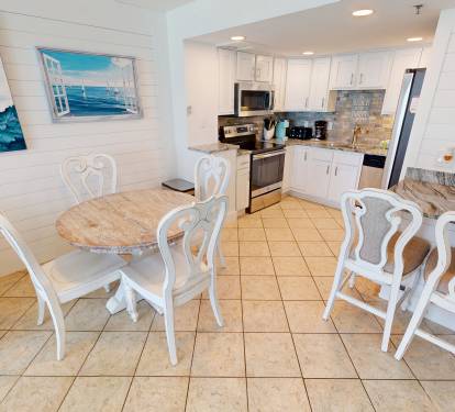 Your bright coastal kitchen and dining space welcomes you with ocean-inspired art, gleaming counters, and a charming breakfast bar where mornings feel relaxed and refreshing.