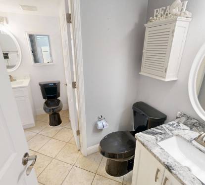 The stylish bathroom features a granite vanity, modern fixtures, and beach-themed décor to help you unwind after a day of coastal adventures.