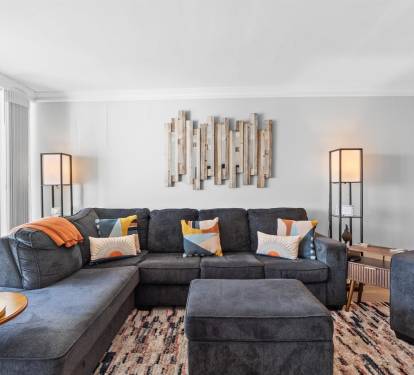 Sink into plush sectional seating with vibrant pillows, perfect for movie nights or morning coffee in your stylish retreat.