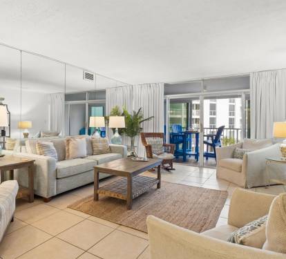 Sink into plush coastal seating in your bright, airy living room where natural light and beach-inspired decor create the perfect vacation ambiance.
