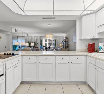 Your spacious kitchen features crisp white cabinets and modern appliances, opening to a bright living area perfect for cooking and entertaining.