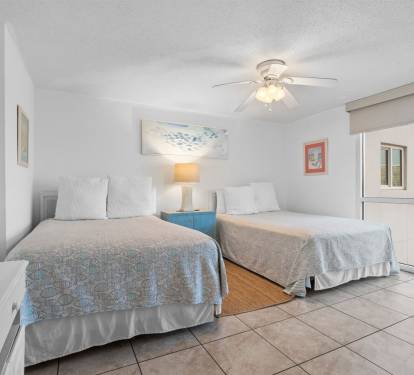 Drift off in your bright Queen bedroom with comfortable beds, coastal artwork, and refreshing ceiling fan breeze.