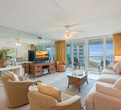 Relax in your elegant beachfront living room with floor-to-ceiling windows framing stunning ocean views and your private balcony.