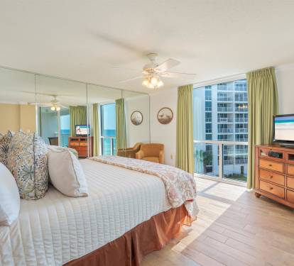 Wake up in your spacious bedroom with plush bedding and floor-to-ceiling windows revealing stunning city and ocean views.