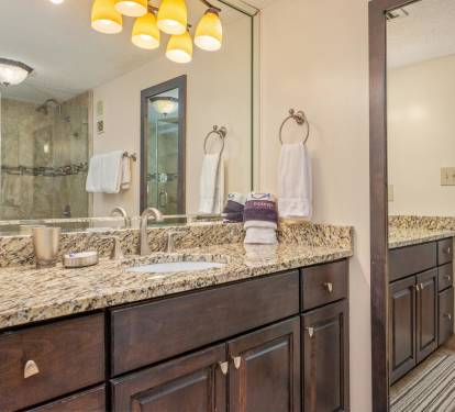 Luxurious master bathroom with granite countertops, dual vanities, and elegant pendant lighting creates your perfect morning routine.
