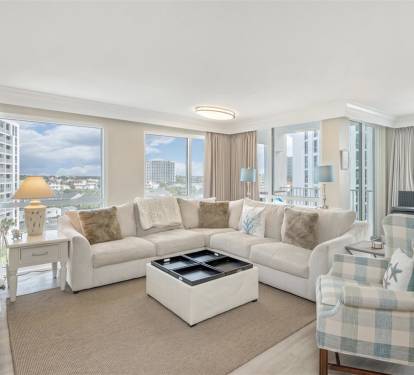 Relax in your bright living room with plush seating and stunning city views through floor-to-ceiling windows.