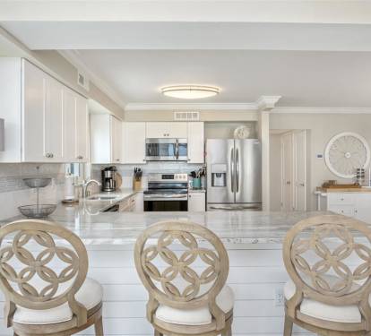 Your elegant kitchen awaits with gleaming marble countertops, stainless steel appliances, and stylish bar seating perfect for morning coffee or evening conversations.