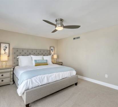 Drift into peaceful dreams in your coastal-inspired bedroom, where soft linens and gentle breezes from the ceiling fan create perfect sleeping comfort.