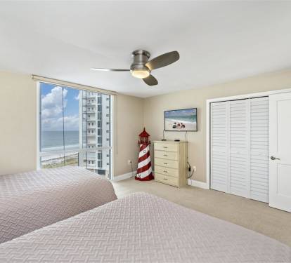 Wake up to stunning ocean views through your floor-to-ceiling windows, with twin beds and ample storage for a perfect beachside retreat.