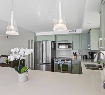 Step into your sleek kitchen featuring sage-green cabinets, granite countertops, and premium stainless appliances—perfect for preparing memorable meals.