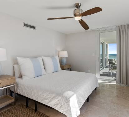 Wake up to ocean breezes in your serene bedroom, where soft linens and gentle ceiling fan create perfect comfort for restful nights.