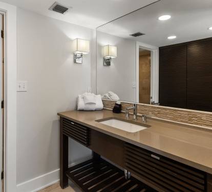 Pamper yourself in this sophisticated bathroom featuring sleek modern fixtures, elegant lighting, and plush towels awaiting your arrival.